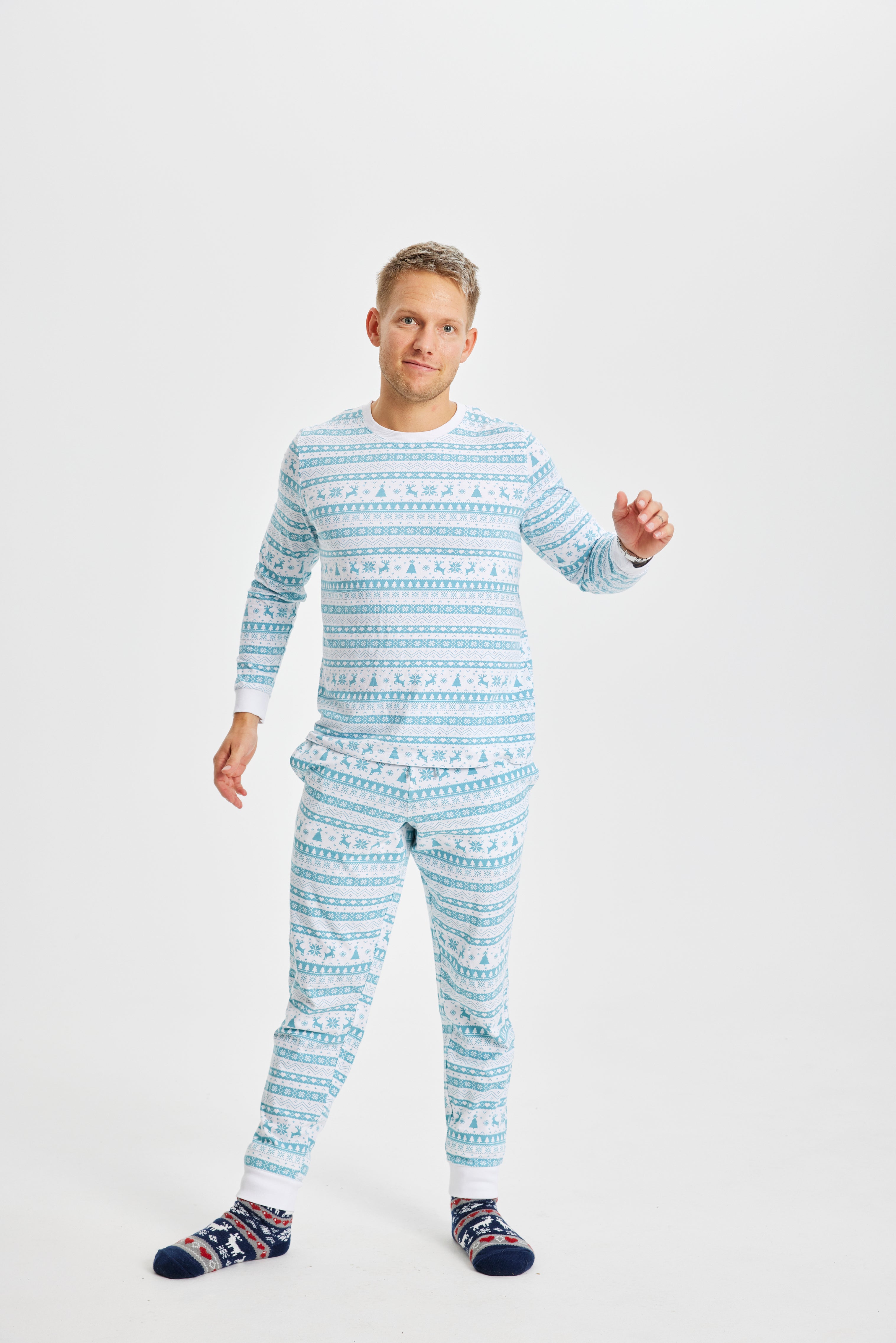 En poserande man klädd i ljusblå julpyjamas.
